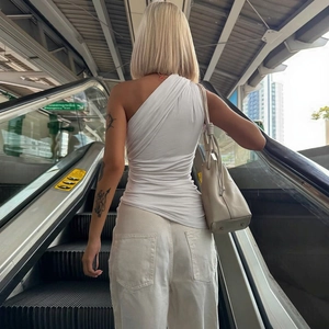 Gros plan d'un débardeur blanc asymétrique plissé avec rubans élégants et dos nu chic