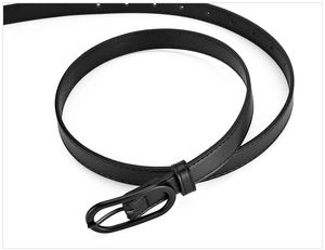 Detail of slim black belt with oval metal buckle and neat stitching on white background