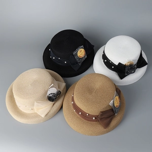 Flat lay of Hepburn style sun hats in four colors with pearl bows and UPF 50+ labels