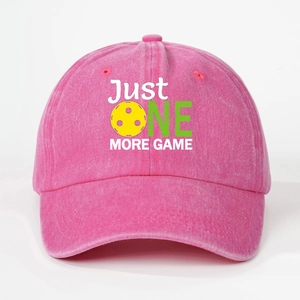 Close-up of pink washed cotton baseball cap with JUST ONE MORE GAME pickleball embroidery