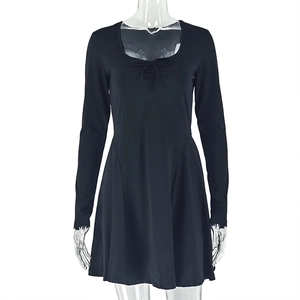 Close-up of black A-line dress featuring a round neck and lace-up chest detail