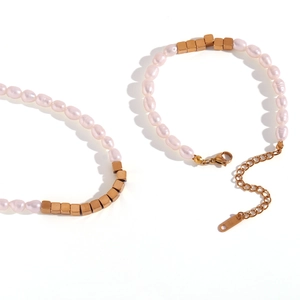 Detailed macro view of pink freshwater pearls and golden cube beads with lobster clasp