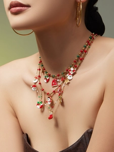 Detail of Christmas necklace with colorful enamel Santa charms and large gold hoops
