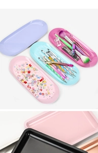 Primo piano di vassoi ovali in plastica colorata per strumenti per unghie e accessori