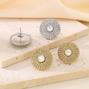Macro shot of sunburst stud earrings with micro-pave crystals on stone surface