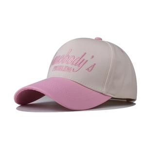 Détail du texte brodé en 3D rose Somebody's PROBLEM sur une casquette en coton