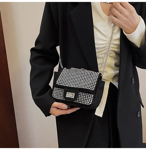 Close-up of sparkling silver rhinestone pattern on luxury black chain bag for party