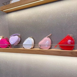 Row of colorful heart-shaped jelly bags in pink, white, and red on a lighted shelf