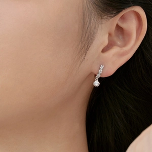 Close-up of S925 sterling silver drop earring with geometric zircon on model ear
