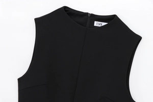 Detail of round neckline and zipper closure on the black faux fur effect dress