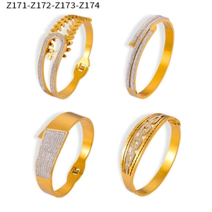 Vue macro de quatre bracelets en acier titane doré avec strass et formes ajourées uniques