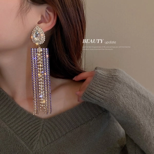 Long water drop tassel earrings with blue and clear crystals on a female model