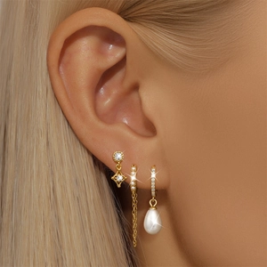 Detail of gold petal earrings with pearls, zircon diamonds and long tassel chains