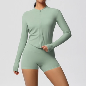 Detail of mint green yoga set featuring zipper jacket with thumb holes and high waist shorts