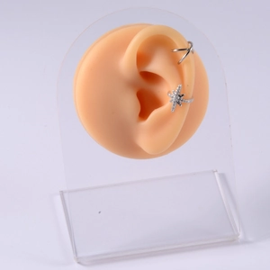 Silver double-layer ear cuff and rhinestone star earring on realistic silicone ear model