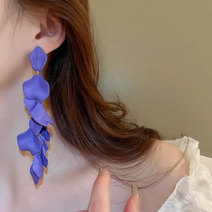 Detail of long purple petal tassel earrings with matte finish worn by a model