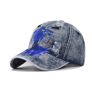 Distressed washed denim baseball cap with blue graffiti sheep graphic and streetwear style