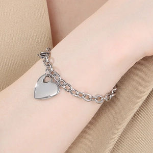 Detailed shot of a silver heart pendant bracelet on a wrist with round chain links