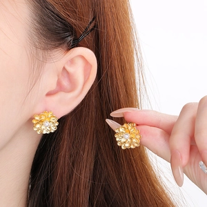 Detail view of vintage gold flower stud earrings with layered shell petals and center pearl