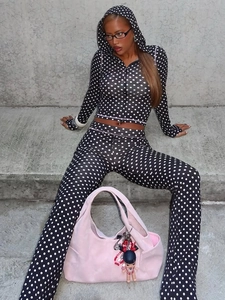 Set aus Kapuzenjacke mit Polka Dots und Schlaghose, getragen auf Betontreppen von Model