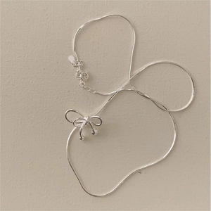 Macro view of S925 sterling silver necklace showing bow pendant and lobster clasp detail