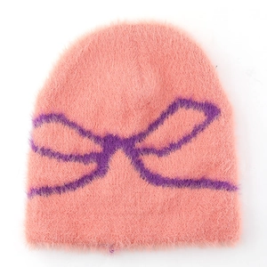Close-up of pink knit beanie with purple bow pattern and soft mohair texture
