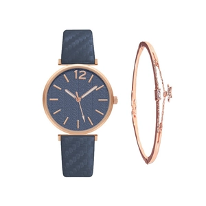 Detail of rose gold watch with blue leaf pattern dial and matching star charm bracelet