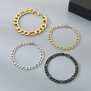 Close-up of Figaro chains in gold, silver, bicolor, and black finishes on a grey background