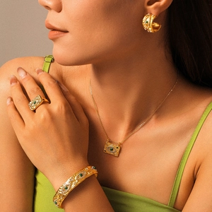 Vintage Goldschmuck-Set mit bösem Blick und grünen Steinen an einem Damenmodell