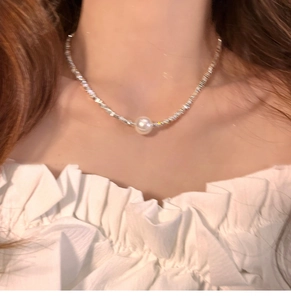 Close-up of a silver beaded pearl necklace on a neck, highlighting elegant luxury style