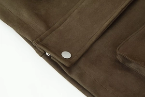 Detail of silver zipper and metal snaps on olive green suede bomber jacket texture