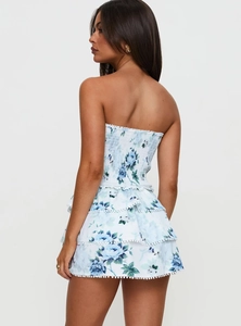 Détail du dos de la mini robe florale avec ourlet à volants et bordure à pompons