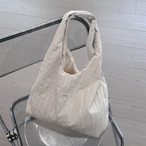 Detailed view of off-white pleated fabric hobo bag showing rich texture and stitching