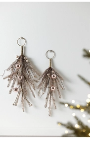 Close-up of rose gold Christmas hanging ornaments with metallic needles and shiny baubles
