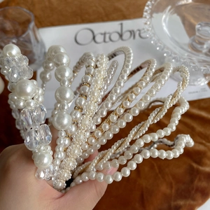 Close-up of elegant pearl and crystal headbands with vintage gold chain details