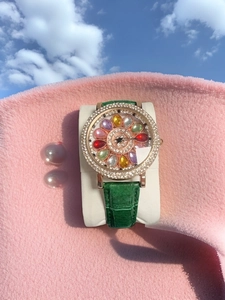 Detailed close-up of a women's watch featuring a diamond-set dial and green leather strap