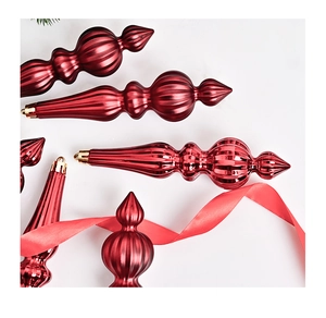 Detailed view of red metallic teardrop and bulb ornaments with gold hanging loops
