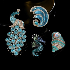 Detail of rhinestone sea animal brooches featuring peacock and seahorse shapes