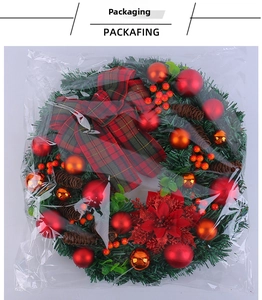 Detail of a Christmas wreath with red bows, berries, pine cones and shiny ornaments