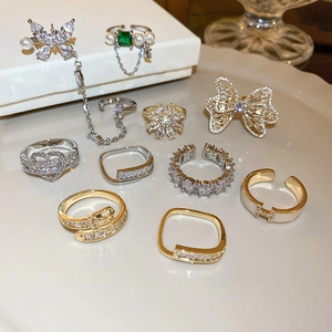 Macro detail of bow and heart shaped rings with zircon and pearl in gold finish