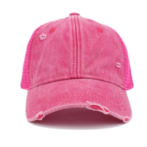 Detailed macro view of distressed pink washed cotton baseball cap with mesh back and holes