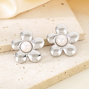 Macro shot of silver petal texture and pearl center on the floral drop earrings