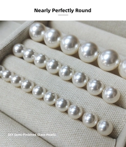 Macro shot of 2-14mm semi-finished glass pearls for DIY jewelry in a beige velvet tray