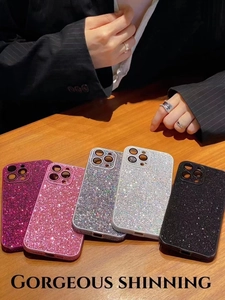 Detail view of shimmering glitter iPhone cases in multiple luxury colors on wooden surface