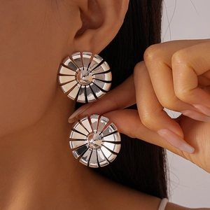 Macro shot of large silver radial petal earrings with high-polish mirror finish on model