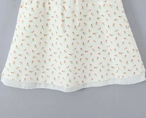 Detail view of the floral A-line skirt with double-layer hem and delicate red flower pattern