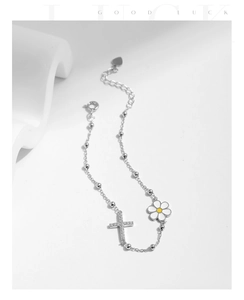 Macro detail of silver daisy and cross charm bracelet with sparkling zircon stones