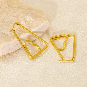 Minimalist geometric heart earrings in gold finish on natural stone background