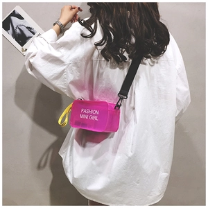 Detail of neon pink mesh crossbody bag with Fashion Mini Girl text and yellow strap