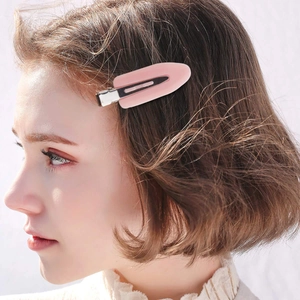 Rosafarbene Haarklammer in Blattform am Haar eines Models für ein professionelles Styling